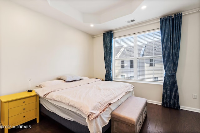 bedroom with recessed lighting, baseboards, dark wood finished floors, and a raised ceiling