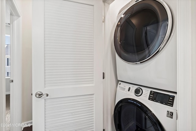 washroom featuring stacked washer / drying machine and laundry area