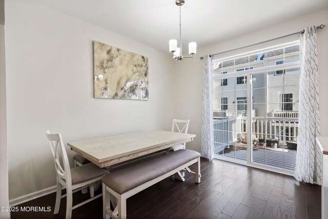 dining room featuring baseboards, dark wood finished floors, and an inviting chandelier