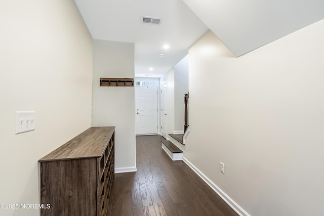 hallway with visible vents, dark wood finished floors, and baseboards