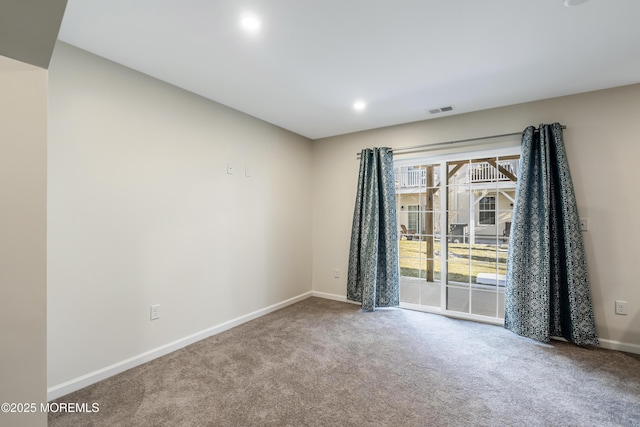 empty room featuring carpet floors, baseboards, and visible vents