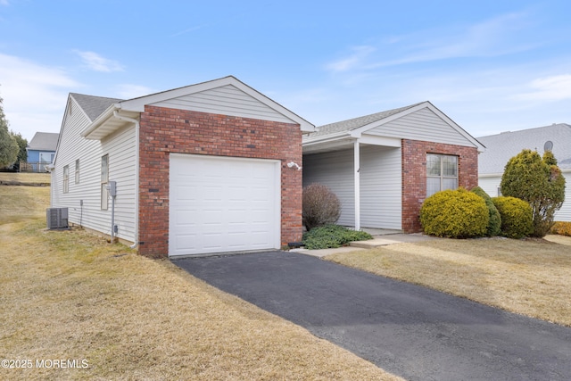 view of front facade featuring an attached garage, brick siding, central AC unit, and a front yard