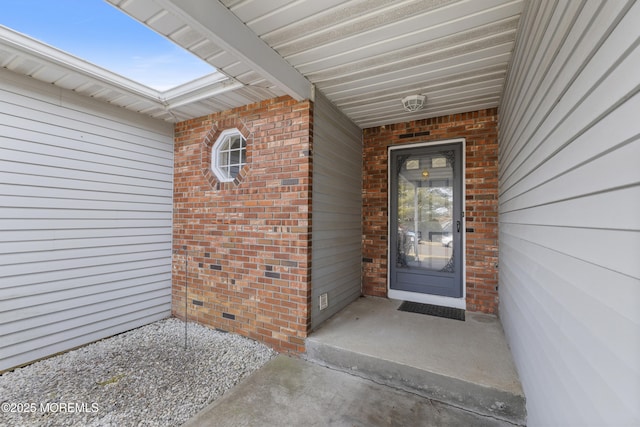 doorway to property featuring crawl space and brick siding