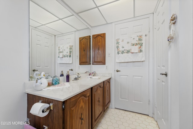 bathroom featuring a paneled ceiling and vanity