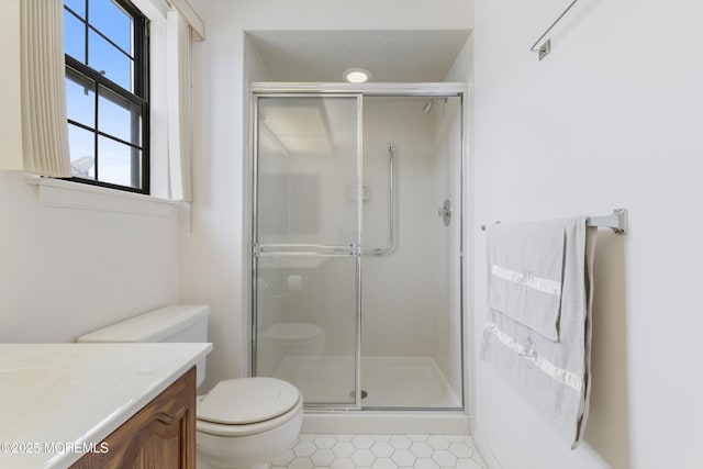 full bath featuring a stall shower, vanity, and toilet