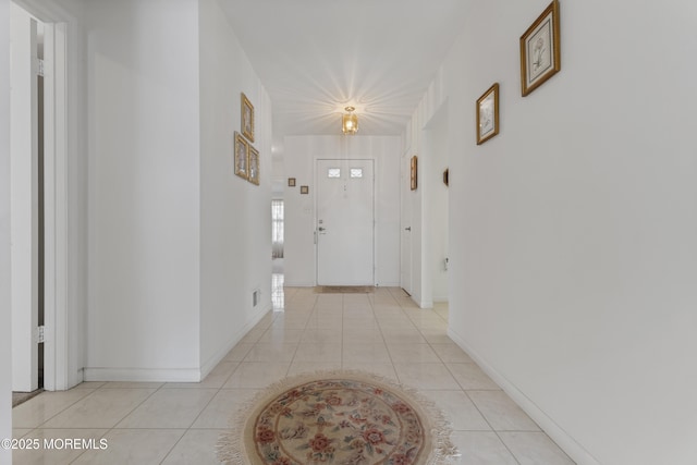 corridor with light tile patterned floors and baseboards