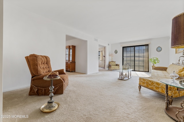 living area with light carpet, visible vents, and a wealth of natural light