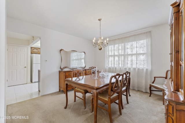 dining room with light carpet, a notable chandelier, and light tile patterned floors