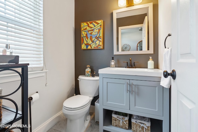 bathroom featuring vanity, toilet, and baseboards