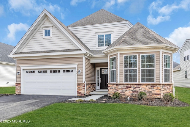 view of front facade with aphalt driveway, a shingled roof, a front yard, a garage, and stone siding