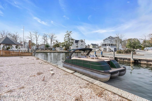 view of dock with a gazebo, a water view, and a residential view