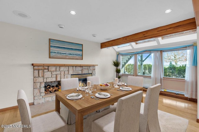 dining space with light wood-type flooring, recessed lighting, a fireplace, and baseboards