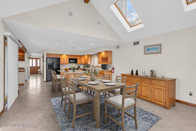 dining room with high vaulted ceiling, a skylight, visible vents, and baseboards