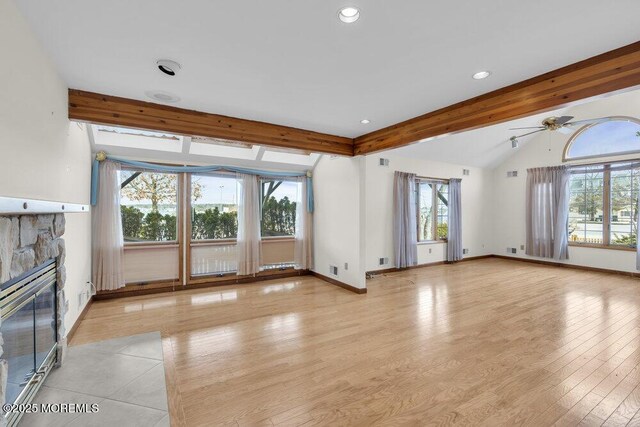 unfurnished living room with a fireplace, recessed lighting, lofted ceiling with beams, light wood-type flooring, and baseboards