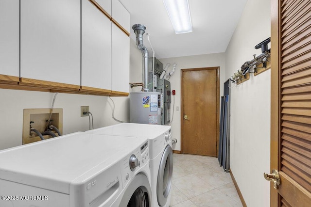 washroom featuring cabinet space, water heater, washer and dryer, and light tile patterned flooring