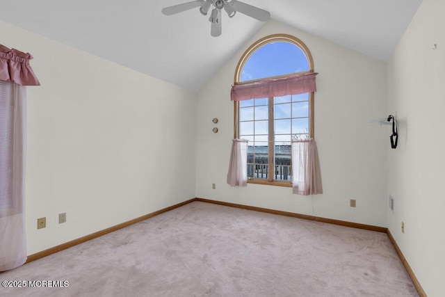 empty room with a ceiling fan, carpet, vaulted ceiling, and baseboards