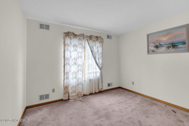 carpeted empty room featuring visible vents and baseboards