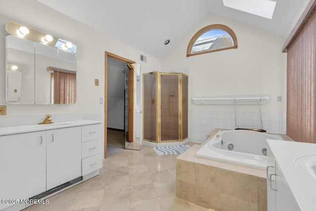 full bathroom featuring a stall shower, a skylight, visible vents, a tub with jets, and two vanities