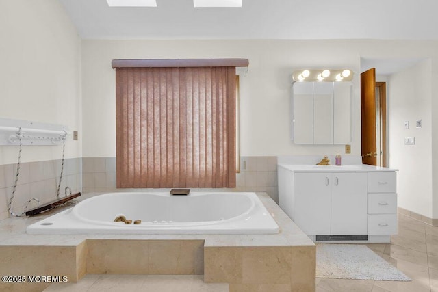 full bathroom with tile patterned flooring, a garden tub, and vanity