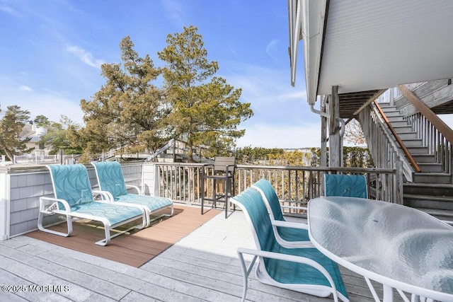 wooden deck featuring stairway and outdoor dining area