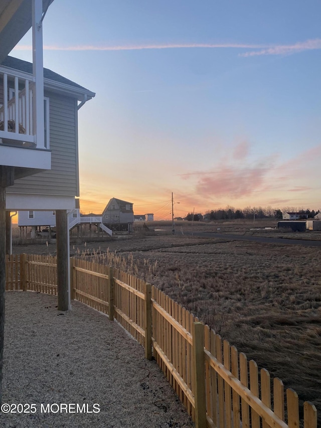 yard at dusk featuring fence