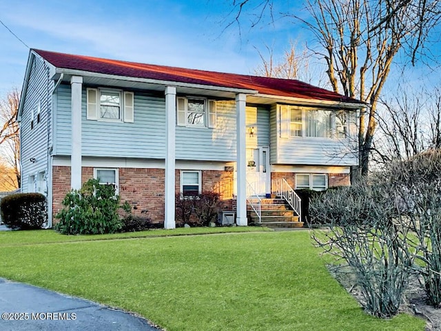 bi-level home with brick siding and a front lawn