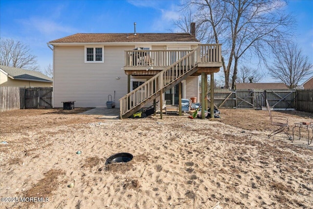 back of property featuring a deck, a gate, a fenced backyard, and stairway