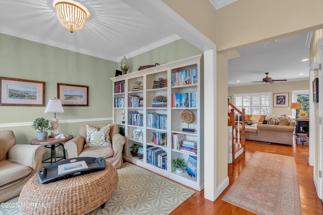 sitting room featuring recessed lighting, light wood-style flooring, ornamental molding, a ceiling fan, and stairs