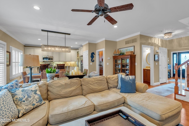 living area featuring plenty of natural light, visible vents, and crown molding