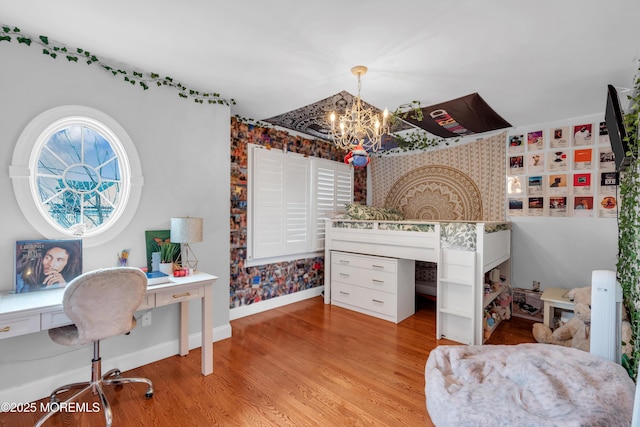 bedroom featuring light wood-style flooring, baseboards, and a notable chandelier