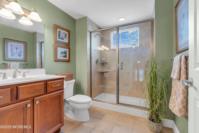 bathroom featuring tile patterned flooring, toilet, a notable chandelier, vanity, and a stall shower