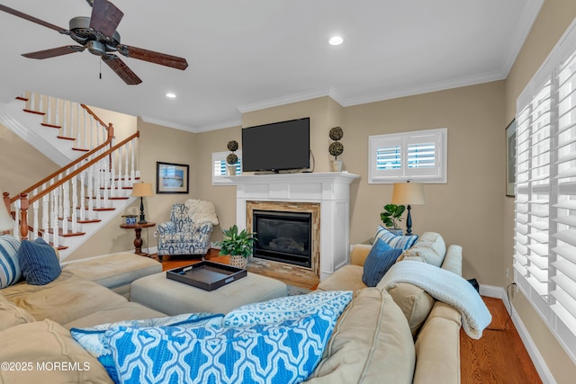 living room with recessed lighting, a fireplace, wood finished floors, baseboards, and crown molding