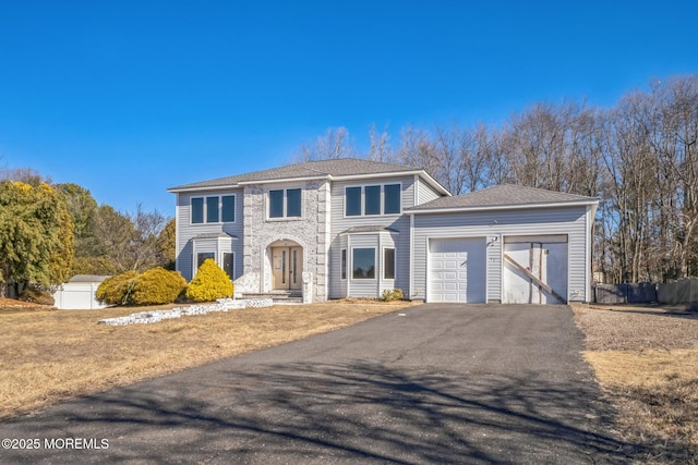 view of front facade featuring a garage, stone siding, and aphalt driveway