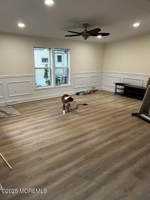 exercise room with ceiling fan, recessed lighting, a decorative wall, and wood finished floors