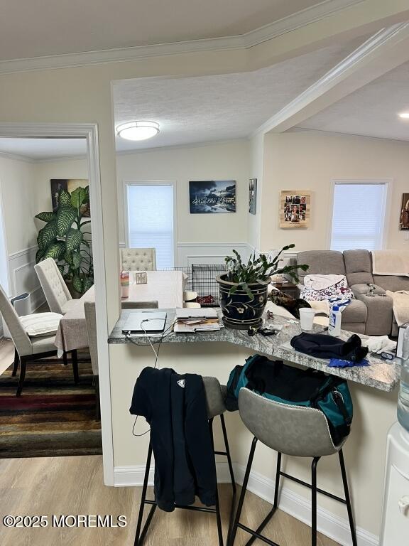 dining area featuring ornamental molding and wood finished floors