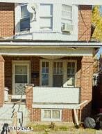 exterior space featuring brick siding and a porch