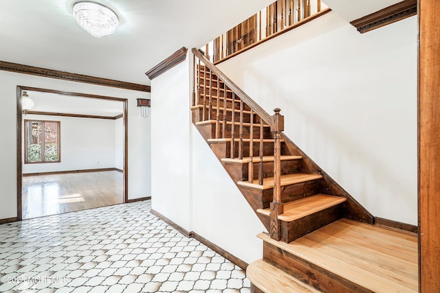 staircase with baseboards, ornamental molding, and tile patterned floors