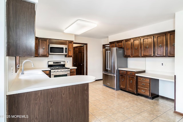 kitchen featuring dark brown cabinetry, appliances with stainless steel finishes, light countertops, and a sink