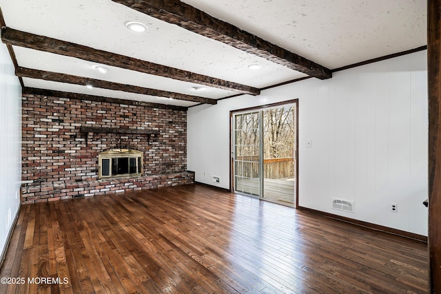 unfurnished living room with a textured ceiling, hardwood / wood-style floors, a fireplace, and visible vents