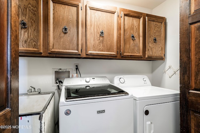 laundry area featuring washer and clothes dryer and cabinet space