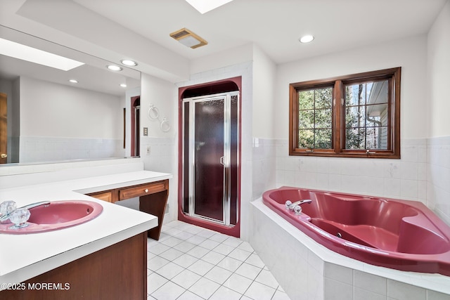 bathroom featuring a stall shower, tile patterned floors, a garden tub, vanity, and recessed lighting