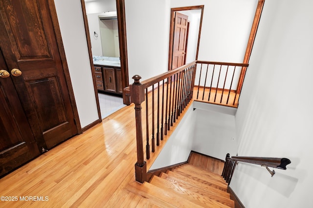 stairs with wood finished floors and baseboards