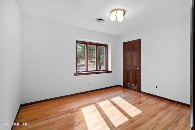 unfurnished room featuring light wood-style flooring, visible vents, and baseboards