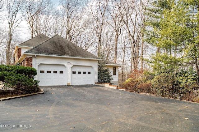 view of side of property featuring a garage and brick siding