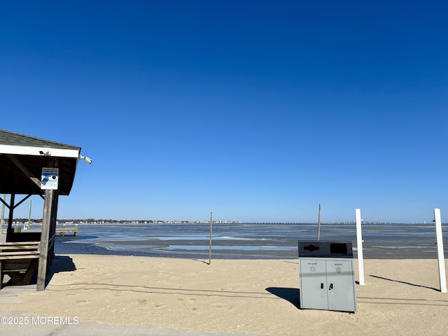 view of home's community with a water view and a beach view