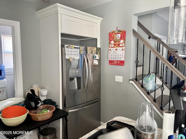 kitchen with stainless steel fridge and white cabinetry