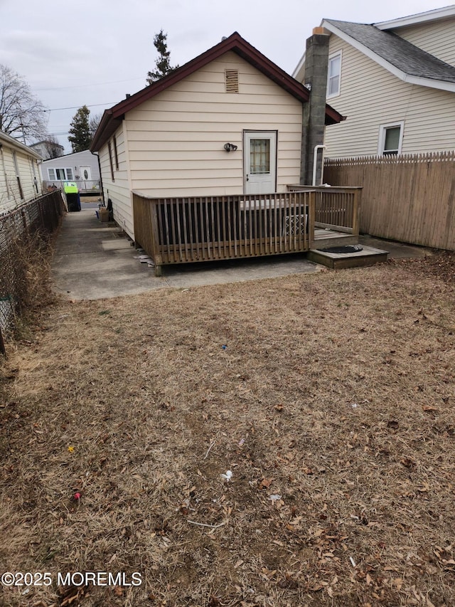 back of property featuring fence and a wooden deck