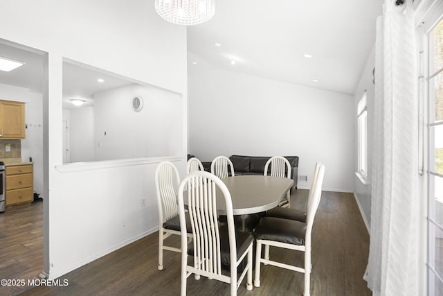 dining area featuring an inviting chandelier, wood finished floors, baseboards, high vaulted ceiling, and recessed lighting
