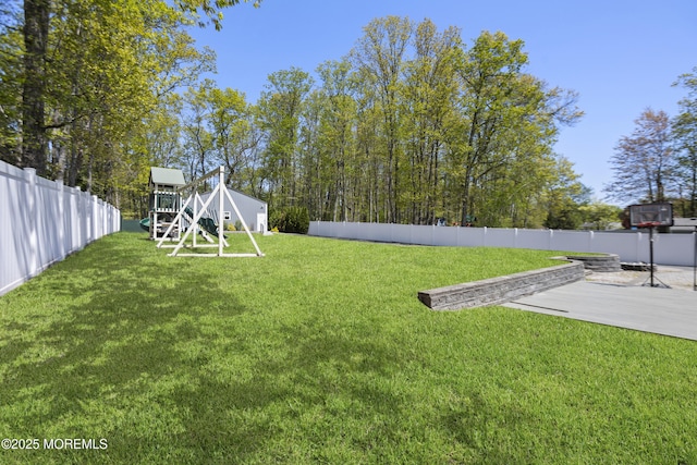 view of yard featuring a fenced backyard, a playground, and a patio area