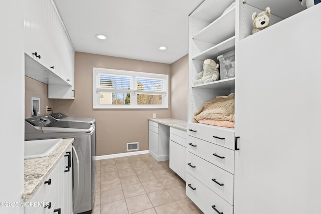 laundry room with visible vents, baseboards, light tile patterned flooring, cabinet space, and independent washer and dryer